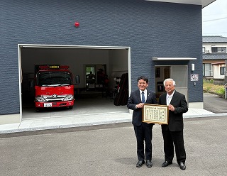 詰所前に立つ市長と寄贈者の写真